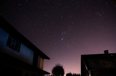 夜晚，星星在房屋上空闪烁